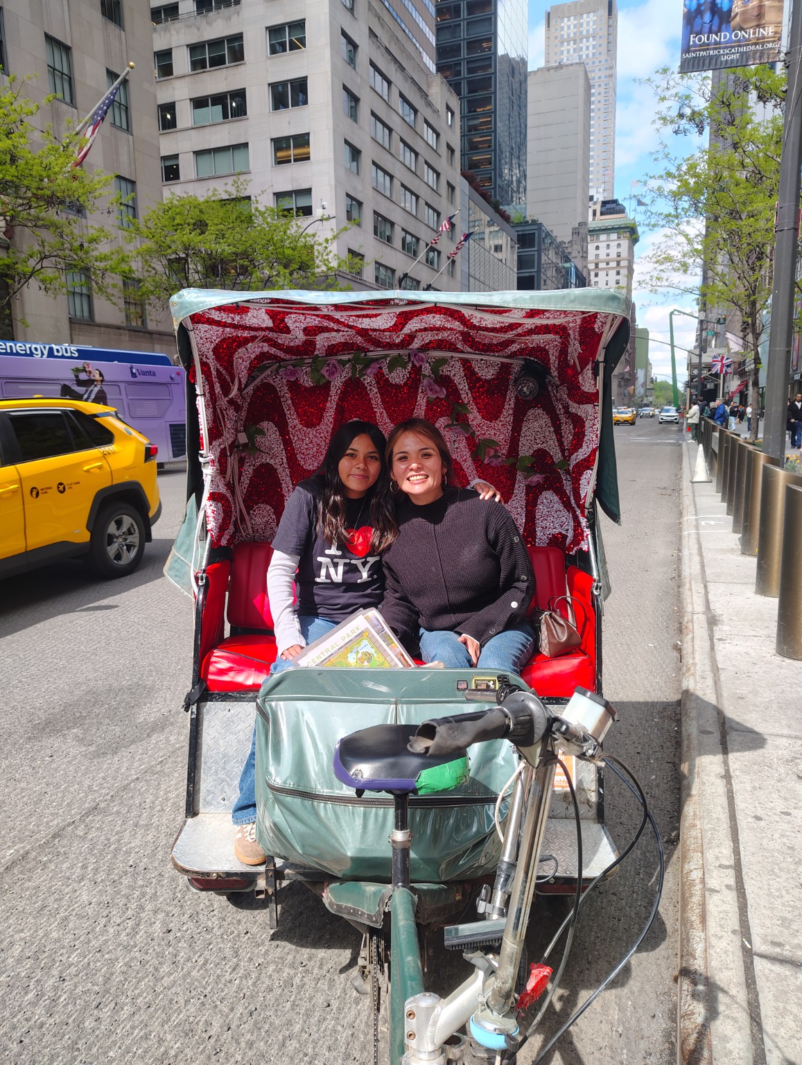 Two guests seated in a decorated pedicab in Midtown Manhattan